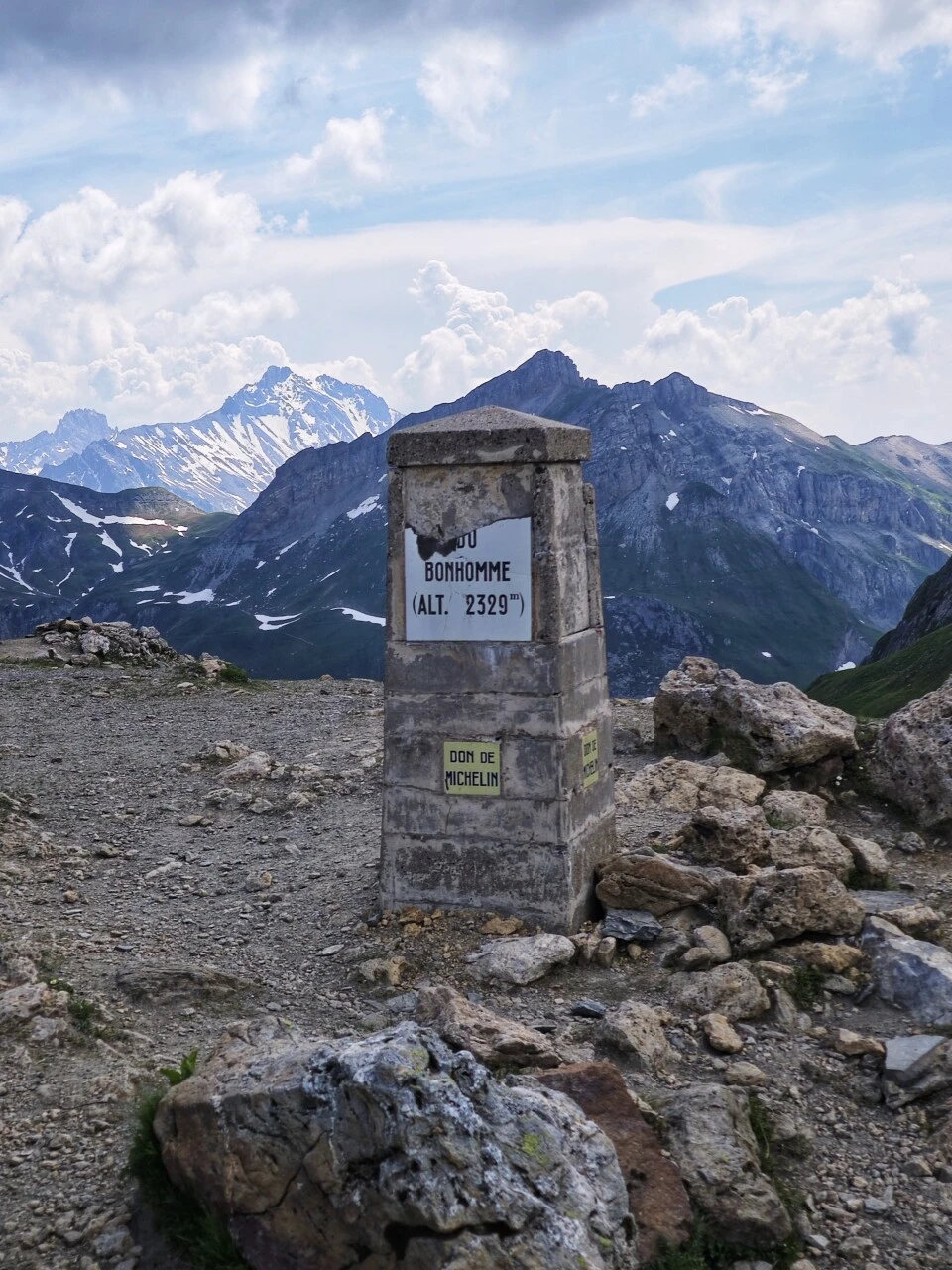 Grenzstein am Col du Bonhomme (2 329 m), zwischen Nebel und verschneiten Gipfeln