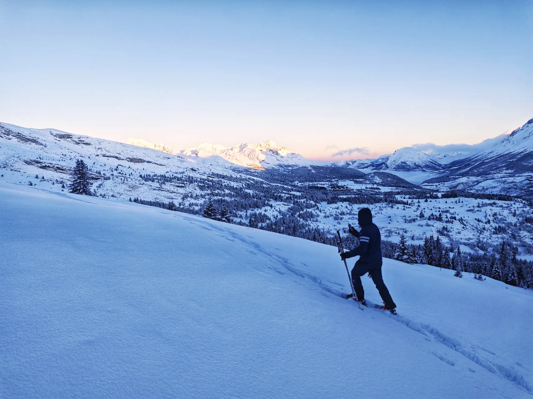 Erste Schritte im unberührten Schnee, vor den im Morgenrot leuchtenden Gipfeln im Dévoluy-Massiv